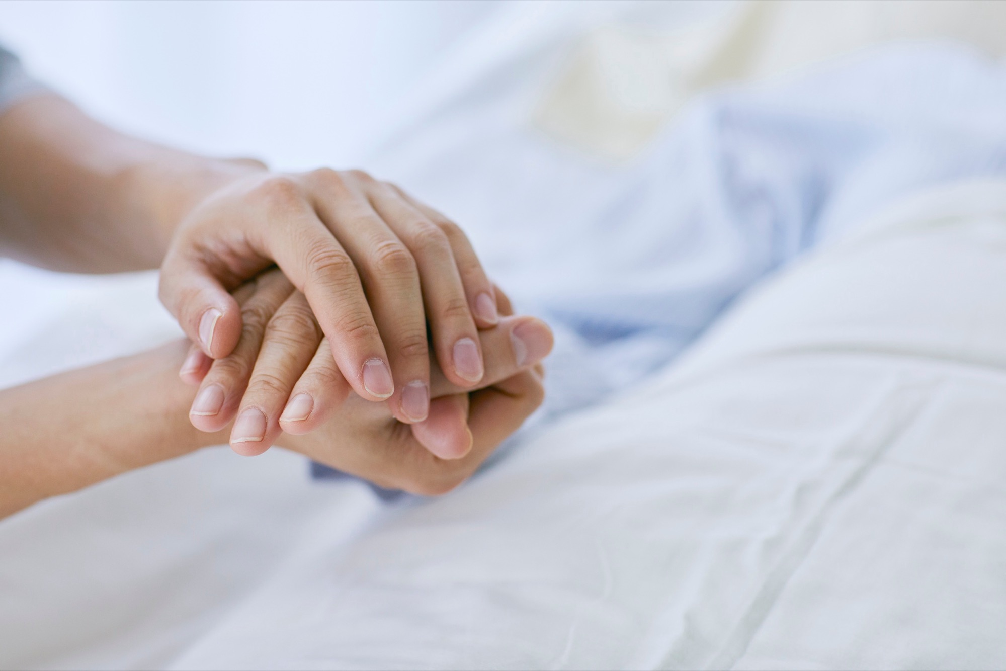A caregiver attends to an elderly person with warmth and care